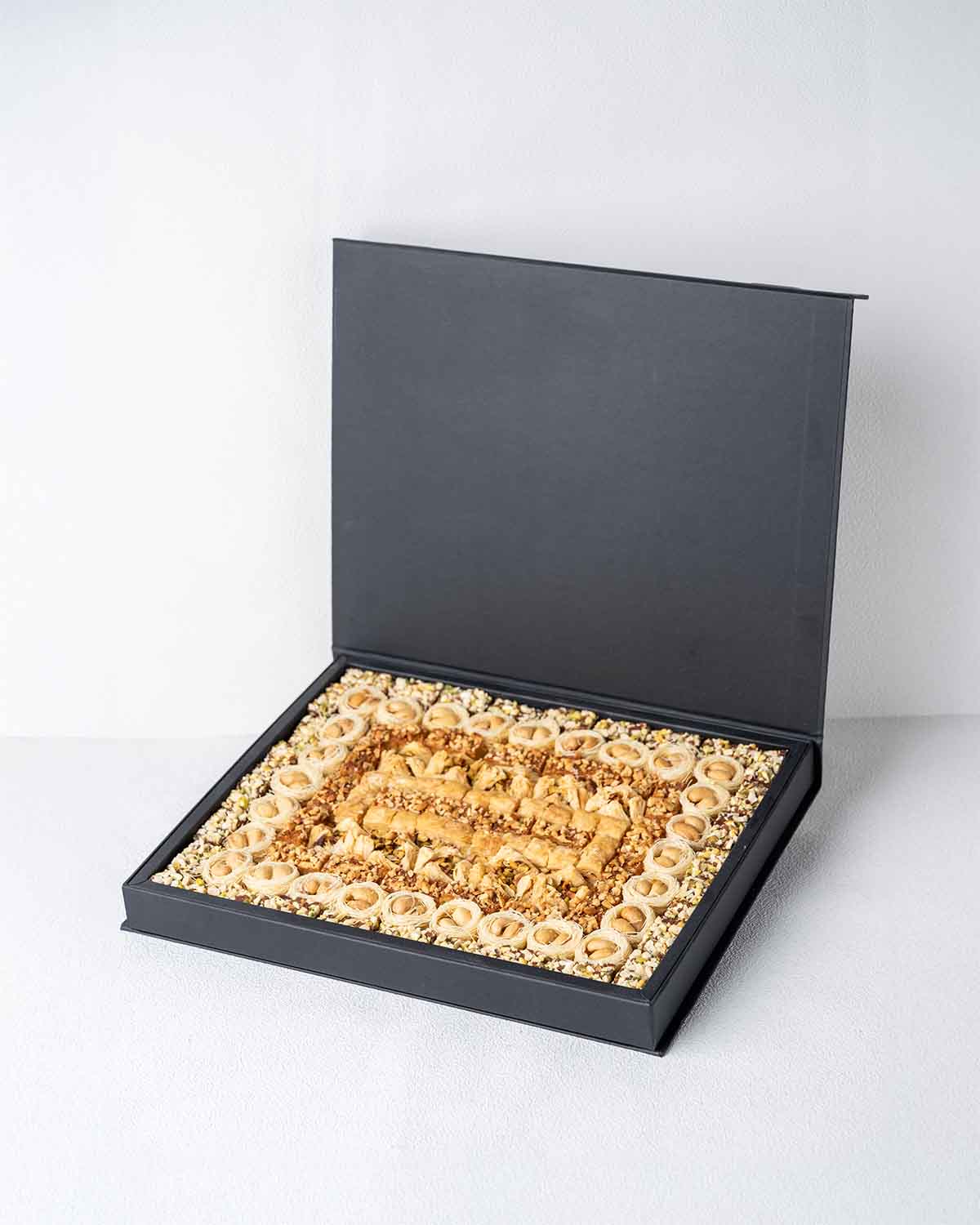 Baklawa Tastes Like EIDChocolate & ConfectioneryYour Gift Contains:• 28 x Esch Cashew• 10 x Bookaj Pistachio• 11 x Assieh Pistachio• 28 x Pistachio Dates• 17 x Cashew Dates• Box Size: 32x26x3.5cmHandling and Storage • Keep away from direct heat and sunlig