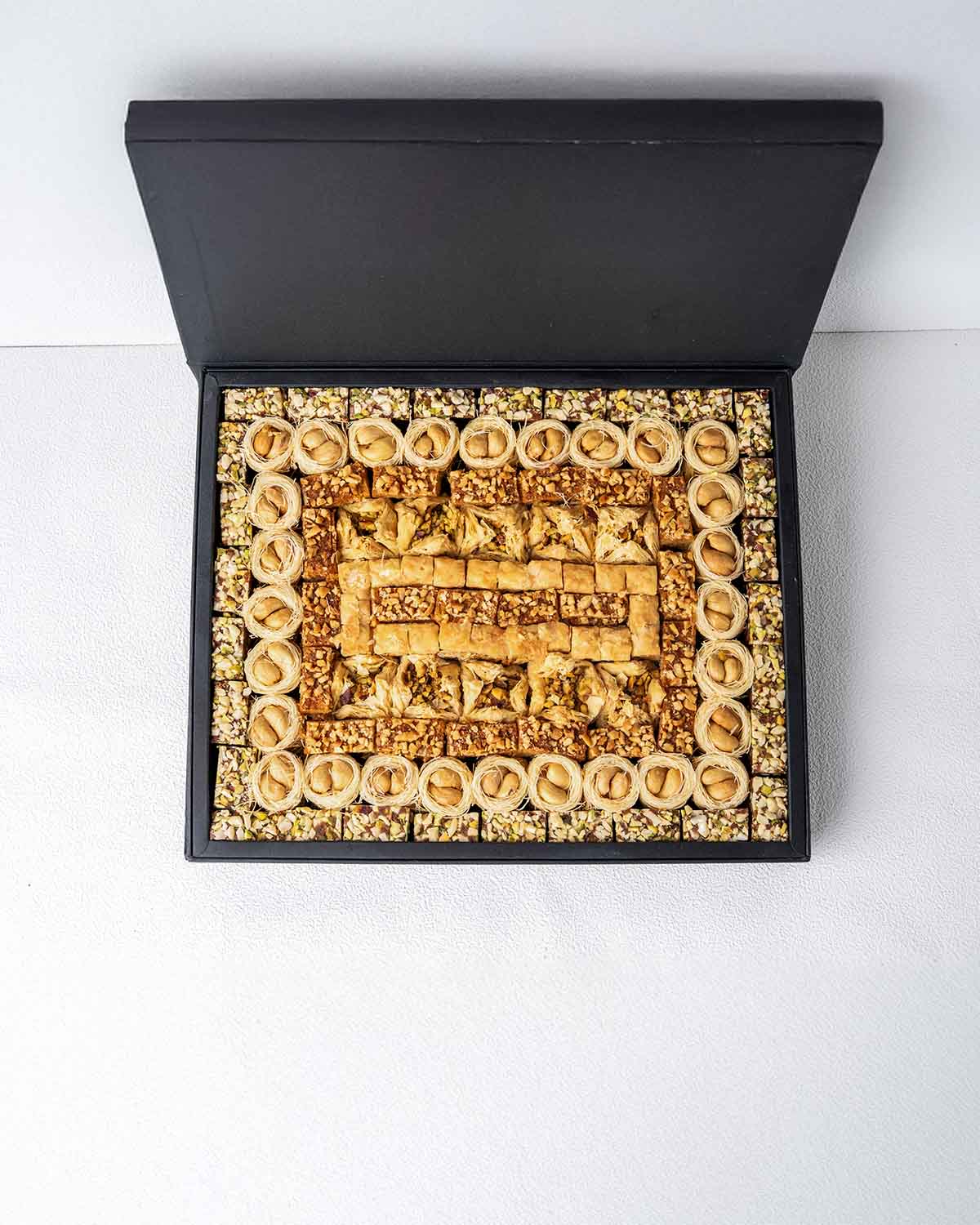Baklawa Tastes Like EIDChocolate & ConfectioneryYour Gift Contains:• 28 x Esch Cashew• 10 x Bookaj Pistachio• 11 x Assieh Pistachio• 28 x Pistachio Dates• 17 x Cashew Dates• Box Size: 32x26x3.5cmHandling and Storage • Keep away from direct heat and sunlig