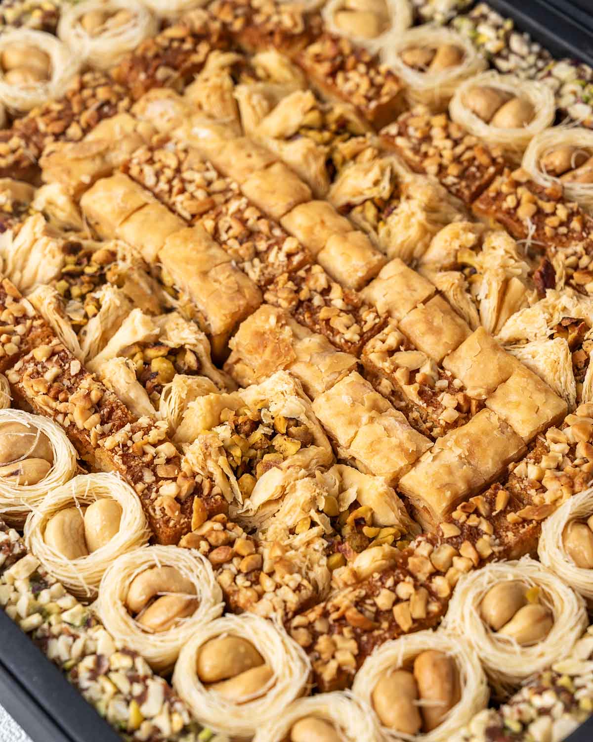 Baklawa Tastes Like EIDChocolate & ConfectioneryYour Gift Contains:• 28 x Esch Cashew• 10 x Bookaj Pistachio• 11 x Assieh Pistachio• 28 x Pistachio Dates• 17 x Cashew Dates• Box Size: 32x26x3.5cmHandling and Storage • Keep away from direct heat and sunlig