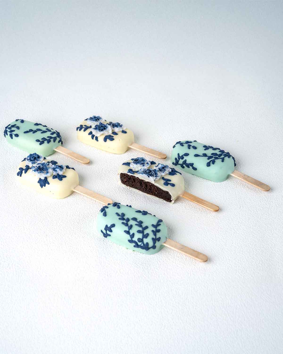 White and Blue CakesiclesChocolate & ConfectioneryWhite and Blue Cakesicles – A Sophisticated Sweet for Any Celebration Add a touch of elegance to your celebration with these beautifully designed white and blue cakesicles. Dipped in smooth chocolate and d