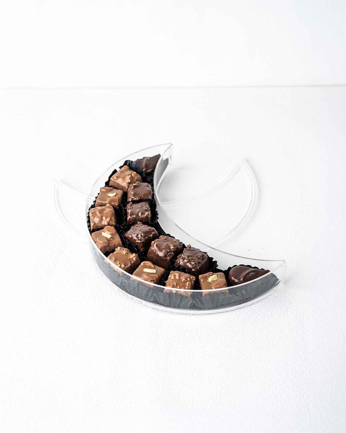 15 Milk and Dark Chocolate Cresent by Cravings CaféChocolate & Confectionery15 Milk and Dark Chocolate Crescents by Cravings Café – A Sweet Symbol of Eid Celebrate the crescent moon of Eid with this elegant box of 15 handcrafted milk and dark chocolates b