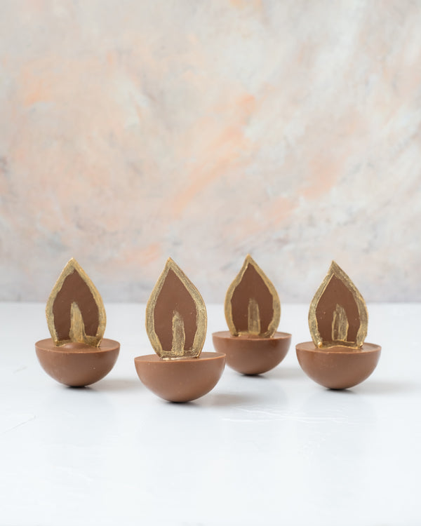 Diya Cake bitesChocolate & ConfectioneryYour Gift Contains: • 4 Milk Chocolate Diya with layers of chocolate cake and ganache • Weight of Chocolate: approx. 350grams • Box Size: 18x18x14cm Handling and Storage • Keep away from direct heat and sunlight • B