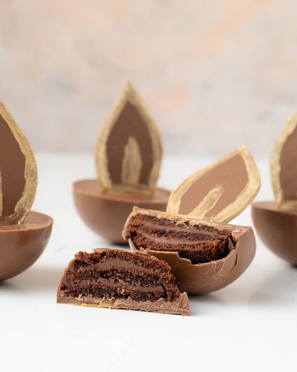 Diya Cake bitesChocolate & ConfectioneryYour Gift Contains: • 4 Milk Chocolate Diya with layers of chocolate cake and ganache • Weight of Chocolate: approx. 350grams • Box Size: 18x18x14cm Handling and Storage • Keep away from direct heat and sunlight • B