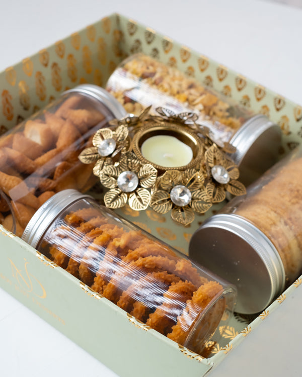 Savory Aaliyah CollectionChocolate & ConfectioneryYour Gift Contains: • 1 designer Diya • 200grams Shankarapali • 110grams Mukrumm • Butter Cookies • 150grams Diet Savory • Box Size: 28x24x8cm • Design of Diya may vary Handling and Storage • Keep away fro