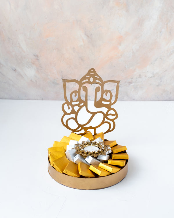 Ganesha Hamper with DiyaChocolate & ConfectioneryYour Gift Contains: • 1 designer Diya • 25 assorted Milk Chocolate • Weigh of chocolate: 400grams • Flavors: Pistachio, Hazelnut, Speculoos, Peanut Butter and Roche • Tray dimensions: 20x23cm • Design of Di