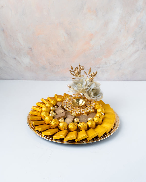 Golden Diwali HamperChocolate & ConfectioneryYour Gift Contains: • 1 designer Diya • 25 assorted Milk Chocolates • 20 assorted Milk Chocolate Truffles • 8 mini golden Milk chocolate bars • 170g of Wheat Crispies chocolate Dragee • Weigh of chocolate: 950g