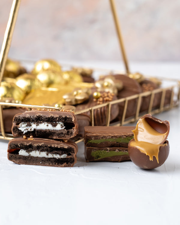 Truffles Oreos and Naps Golden and Brown HamperChocolate & ConfectioneryYour Gift Contains: • 1 designer Diya • 8 assorted Milk chocolates • 12 assorted Milk/Dark chocolate truffles • 20 designer Diwali theme chocolate covered Oreos • Flavors: Pistachio,