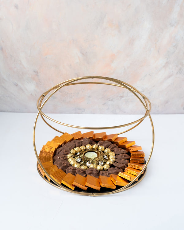 Golden and Orange HamperChocolate & ConfectioneryYour Gift Contains: • 1 designer Diya • 27 assorted Milk chocolates • 19 roasted nuts base Milk chocolate coins • 100gms of Wheat Crispies Dragee • Weigh of chocolate: 850gms approx. • Flavors: Pistachio, H