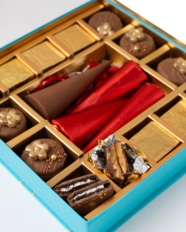 Cookies and Cracker Gift boxChocolate & ConfectioneryYour Gift Contains: • 4 Milk chocolate mini cones • 8 designer chocolate covered Oreo • 6 assorted Belgian Milk chocolate • Weigh of chocolate: 400grams • Flavors: Hazelnut, Speculoos and Roche • Box Si