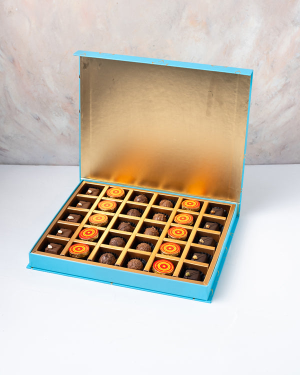 Truffles Bonbon and ChocolateChocolate & ConfectioneryYour Gift Contains: • 10 assorted truffles • 10 Milk chocolate coins • 5 assorted Dark chocolates • 5 assorted Milk chocolates • Weigh of chocolate: 520grams • Flavors: Pistachio, Hazelnut, Speculoos,