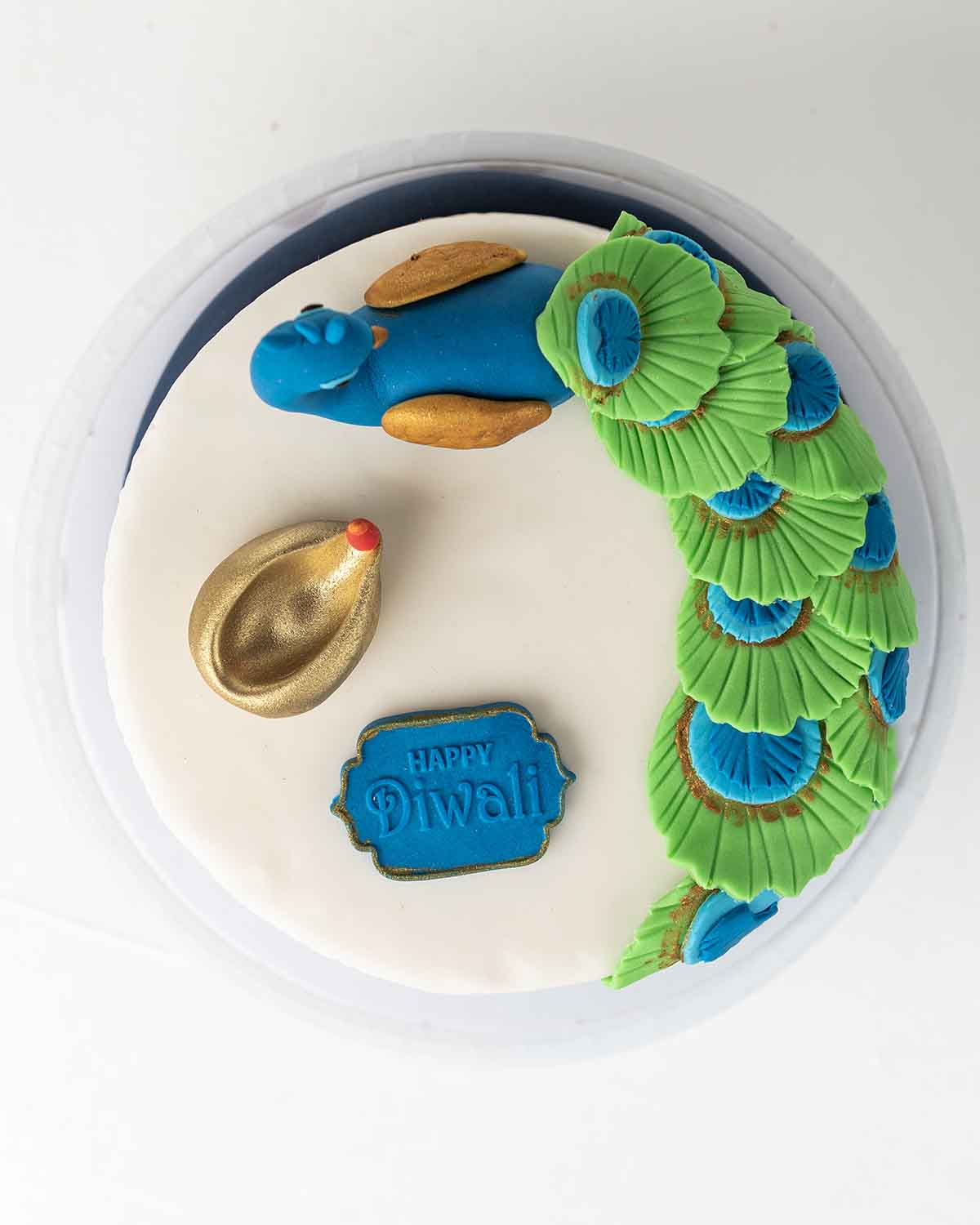 1kg Peacock CakeChocolate & ConfectioneryYour Gift Contains:• 1kg Diwali Theme Cake Peacock cake• Flavor: Chocolate/Vanilla/Red Velvet/Brownie• Box Size: 21x21x25cmHandling and Storage • Keep away from direct heat and sunlight• Best stored between 12-18 °