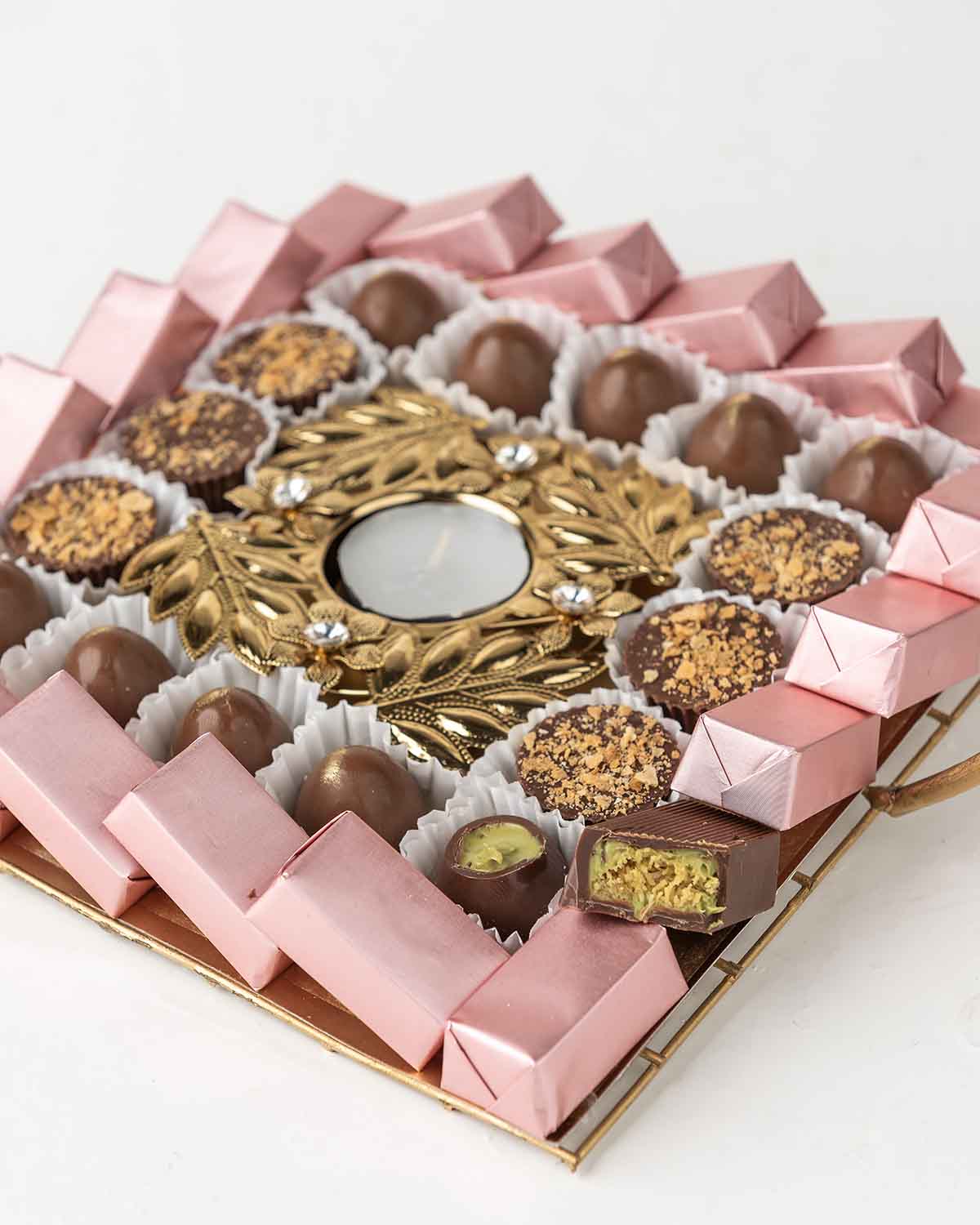 Chocolate Tray by NJDChocolate & ConfectioneryYour Gift Contains:• 1 Diya• 6 Milk Chocolate Topped with Biscoff• 10 milk chocolate truffles• 20 Assorted Milk chocolates• Flavors: Pistachio, Hazelnut, Speculoos, Peanut Butter and Roche (more flavors availa