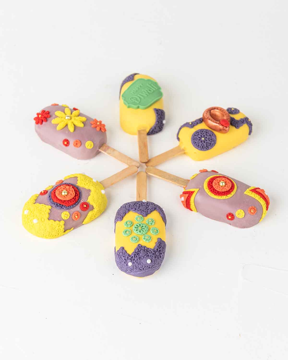 Diwali CakesiclesChocolate & ConfectioneryYour Gift Contains:• 6 x Diwali Theme Cakesicles• Flavors: Chocolate/Vanilla/Red Velvet• Cakesicles Box Size: 35×14.5x4cmHandling and Storage • Keep away from direct heat and sunlight• Best stored between 12-18 °C