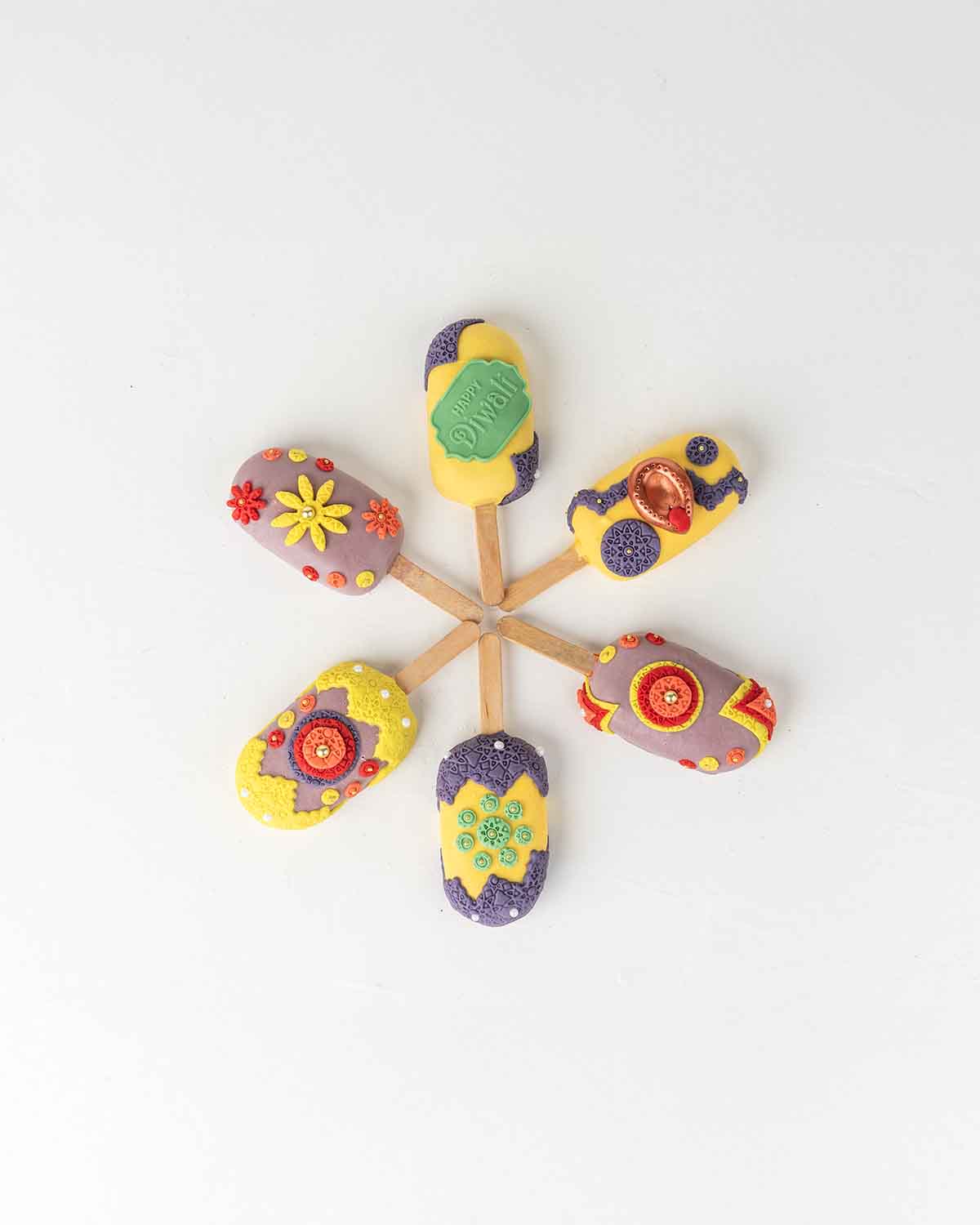 Diwali CakesiclesChocolate & ConfectioneryYour Gift Contains:• 6 x Diwali Theme Cakesicles• Flavors: Chocolate/Vanilla/Red Velvet• Cakesicles Box Size: 35×14.5x4cmHandling and Storage • Keep away from direct heat and sunlight• Best stored between 12-18 °C