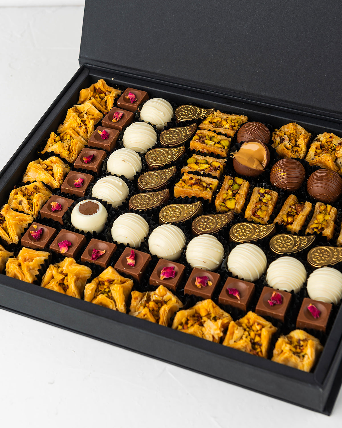 Truffles, Baklawa and Bonbon Gift BoxChocolate & ConfectioneryYour Gift Contains:• 17 x Bookaj Pistachio• 9 x Assieh Pistachio• 25 x Assorted Milk Chocolates• 11 x White Chocolate Truffles• Flavors: Pistachio, Hazelnut, Speculoos, Peanut Butter and Roche