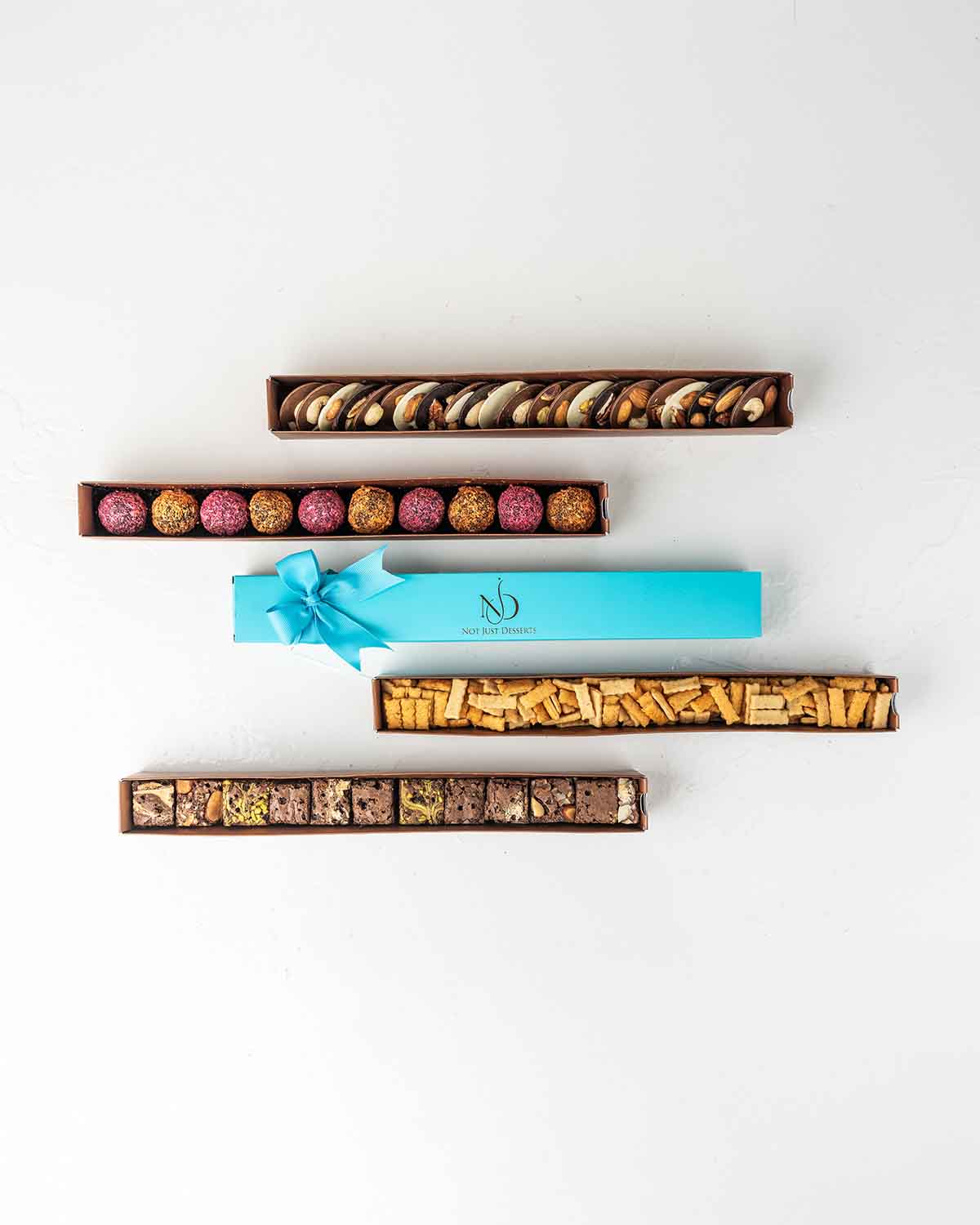 Limited Edition Diwali'24 CollectionChocolate & ConfectioneryYour Gift Contains:• 10 x Assorted French Truffles• 155g Savory Chilly Biscuit • (25pcs)120g White, Milk and Dark Chocolate Coins with Nuts• 250gm (12) Brownie Bites• Box Size: 35x4x4cmHandling