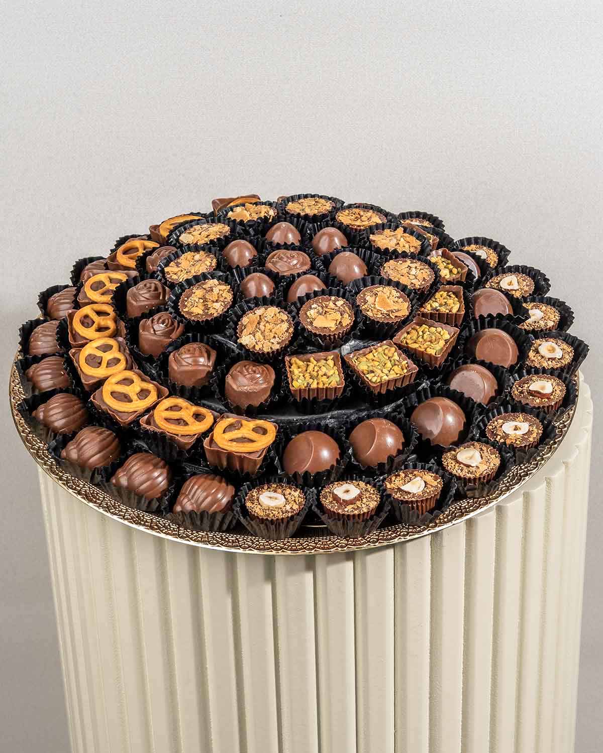 78 Assorted Chocolates ArrangementChocolate & ConfectioneryYour Gift Contains:• 78 assorted Belgian milk chocolates• Flavors: Pistachio, Hazelnut, Speculoos, Peanut Butter and Roche, Coconut, Date and Coffee• Chocolate Weight: 900g• Tray Dimension: 31x31c