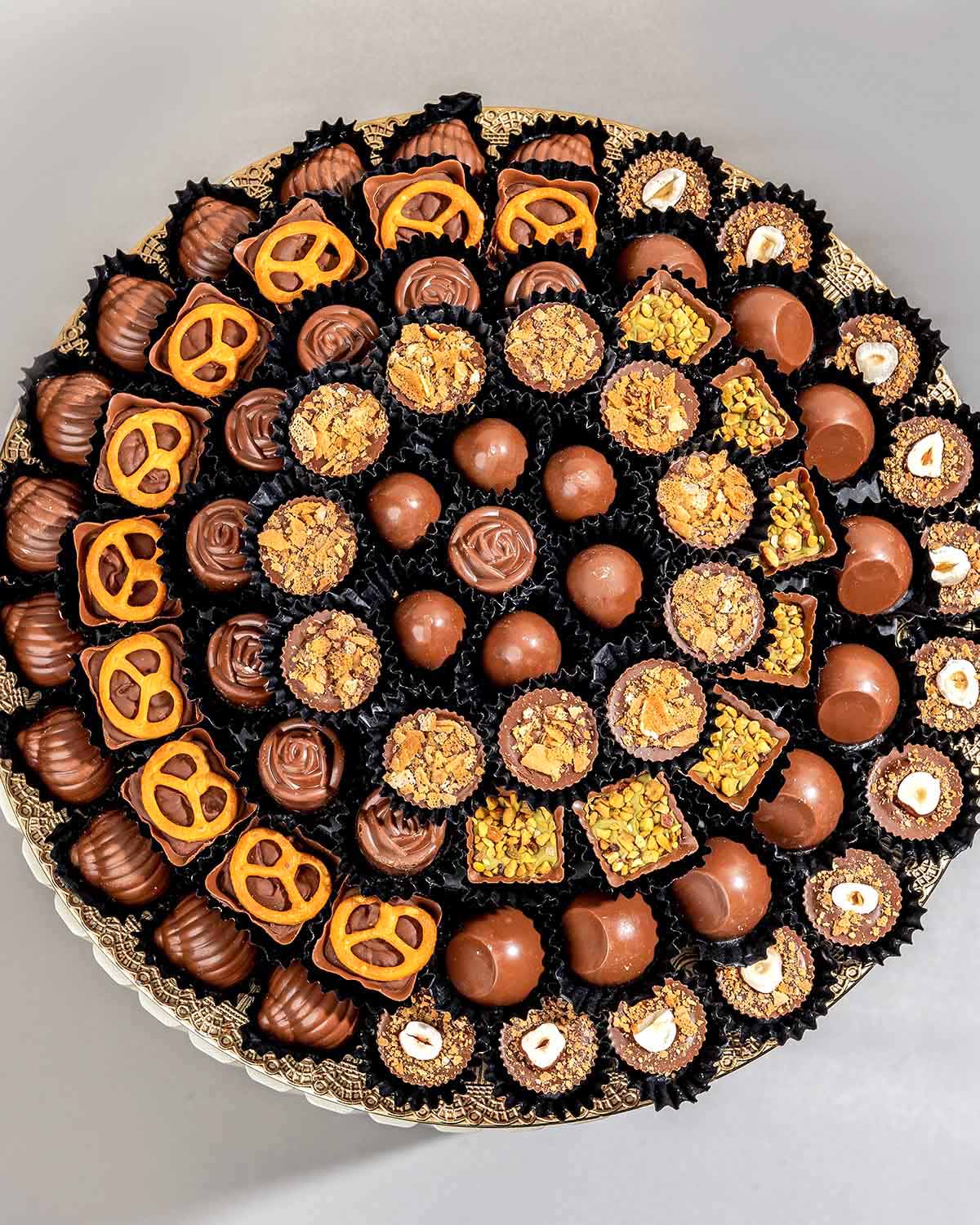 78 Assorted Chocolates ArrangementChocolate & ConfectioneryYour Gift Contains:• 78 assorted Belgian milk chocolates• Flavors: Pistachio, Hazelnut, Speculoos, Peanut Butter and Roche, Coconut, Date and Coffee• Chocolate Weight: 900g• Tray Dimension: 31x31c