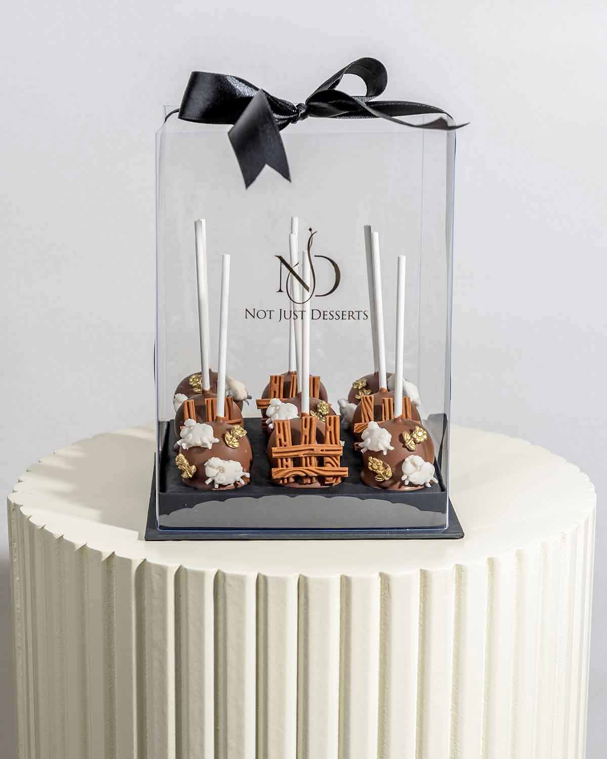 Milk Chocolate EID Cake PopsChocolate & ConfectioneryYour Gift Contains:• 9pcs Eid Al Adha theme cake pops• Flavors available: Chocolate/Vanilla/Red Velvet• Chocolate Weight: 380g• Box Size: 16x16x20cmHandling and Storage • Keep away from direct heat and