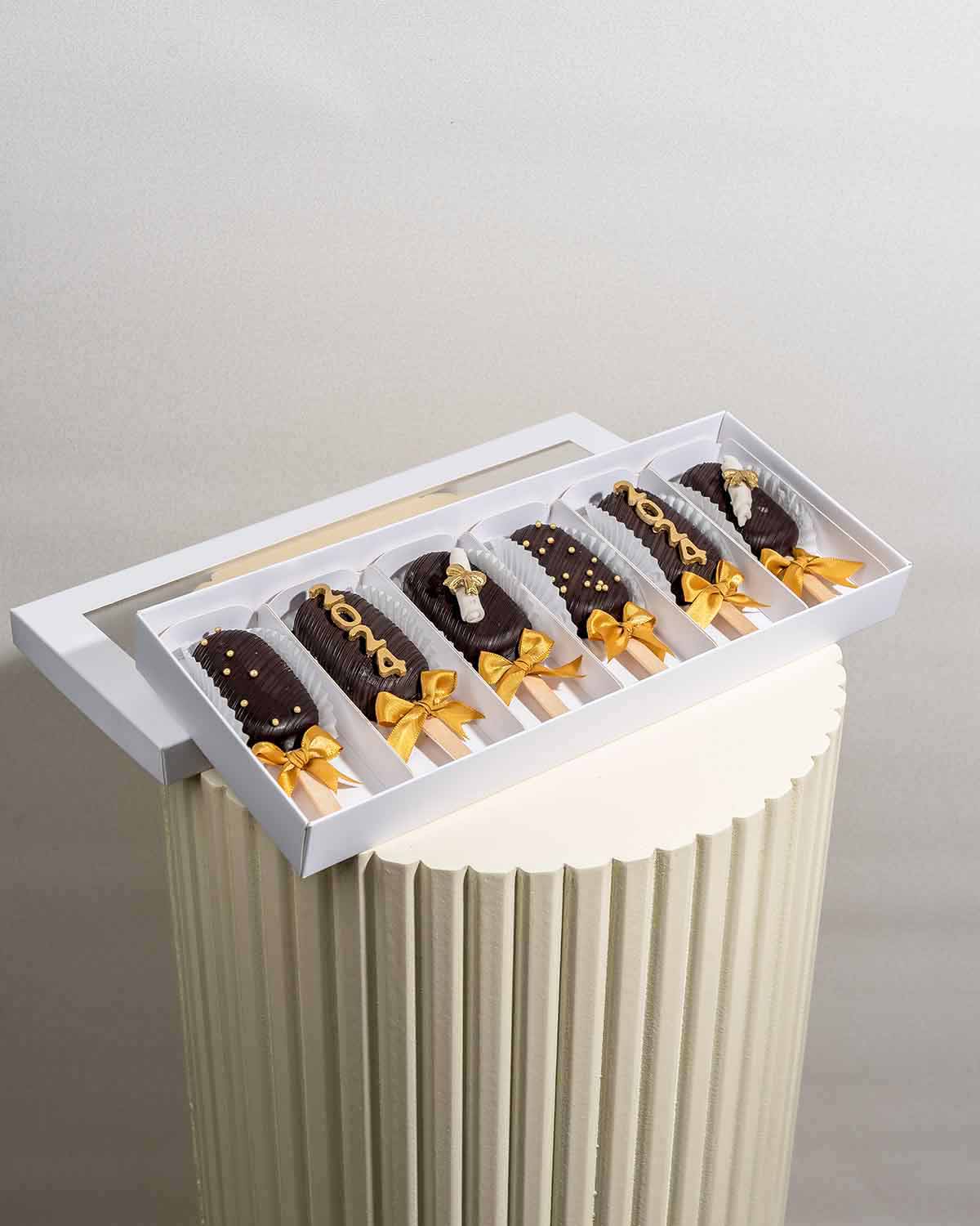 Graduation Cakesicles 2024 by NJDChocolate & ConfectioneryYour Gift Contains:• 6 x Cakesicles• Graduation Theme, Customizable text• Flavors available: Chocolate/Vanilla/Red Velvet• Chocolate Weight: 360g approx.• Box Size: 35x14.5x4cmHandling and Storage