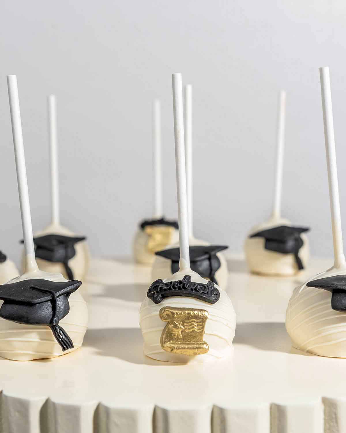 White Chocolate Graduation Cake Pops by NJDChocolate & ConfectioneryYour Gift Contains:• 9 x cake pops• Flavors available: Chocolate/Vanilla/Red Velvet• Chocolate Weight: 530gms approx.• Box Size: 16x16x20cmHandling and Storage • Keep away from direct hea
