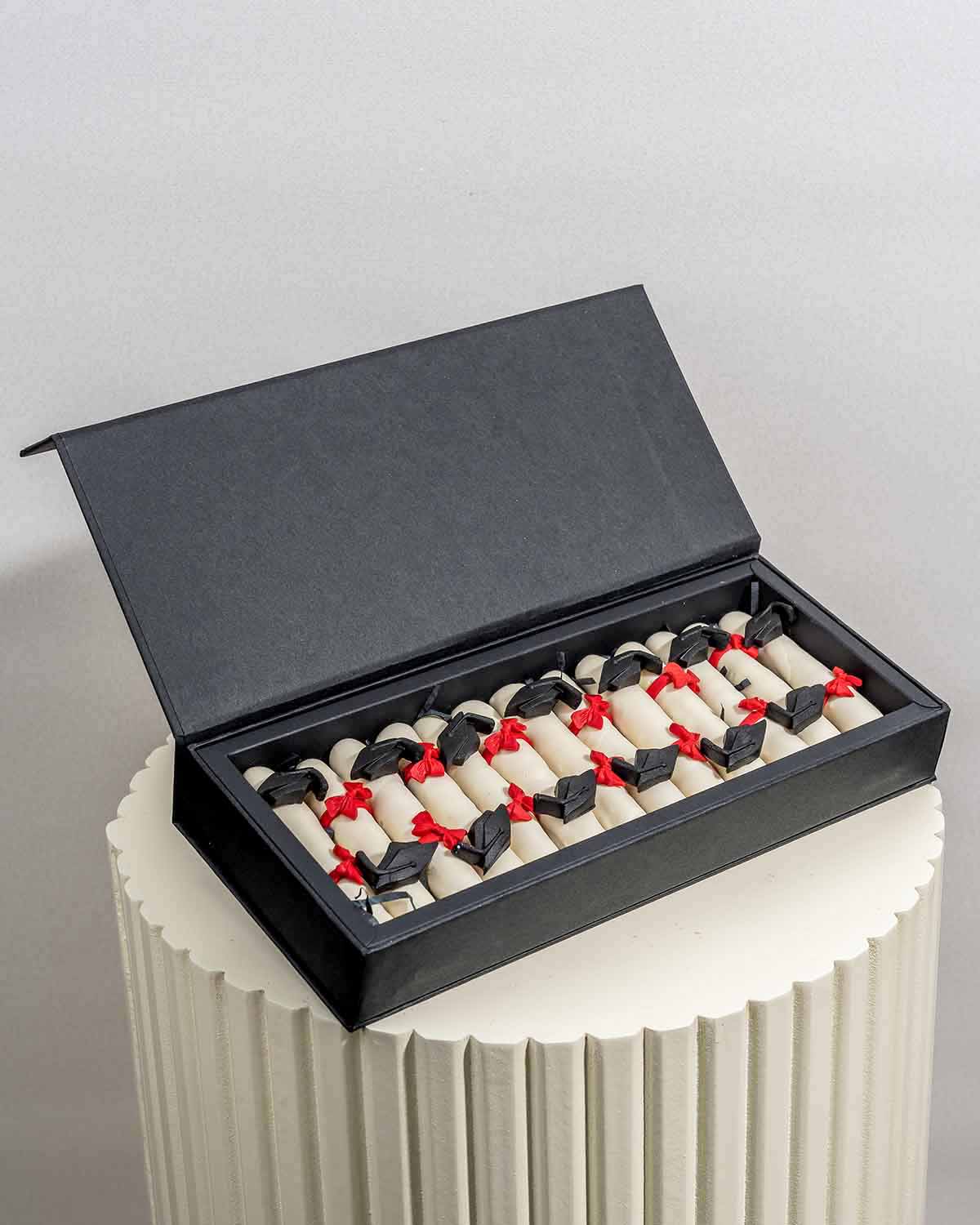 Graduation Theme Chocolate CigarsChocolate & ConfectioneryYour Gift Contains:• 13 x White chocolate covered edible cigars in Graduation theme• Chocolate Weight: 300g• Chocolate Size: 9x1x1.5cm• Box Size: 28x12x4cmHandling and Storage • Keep away from dire