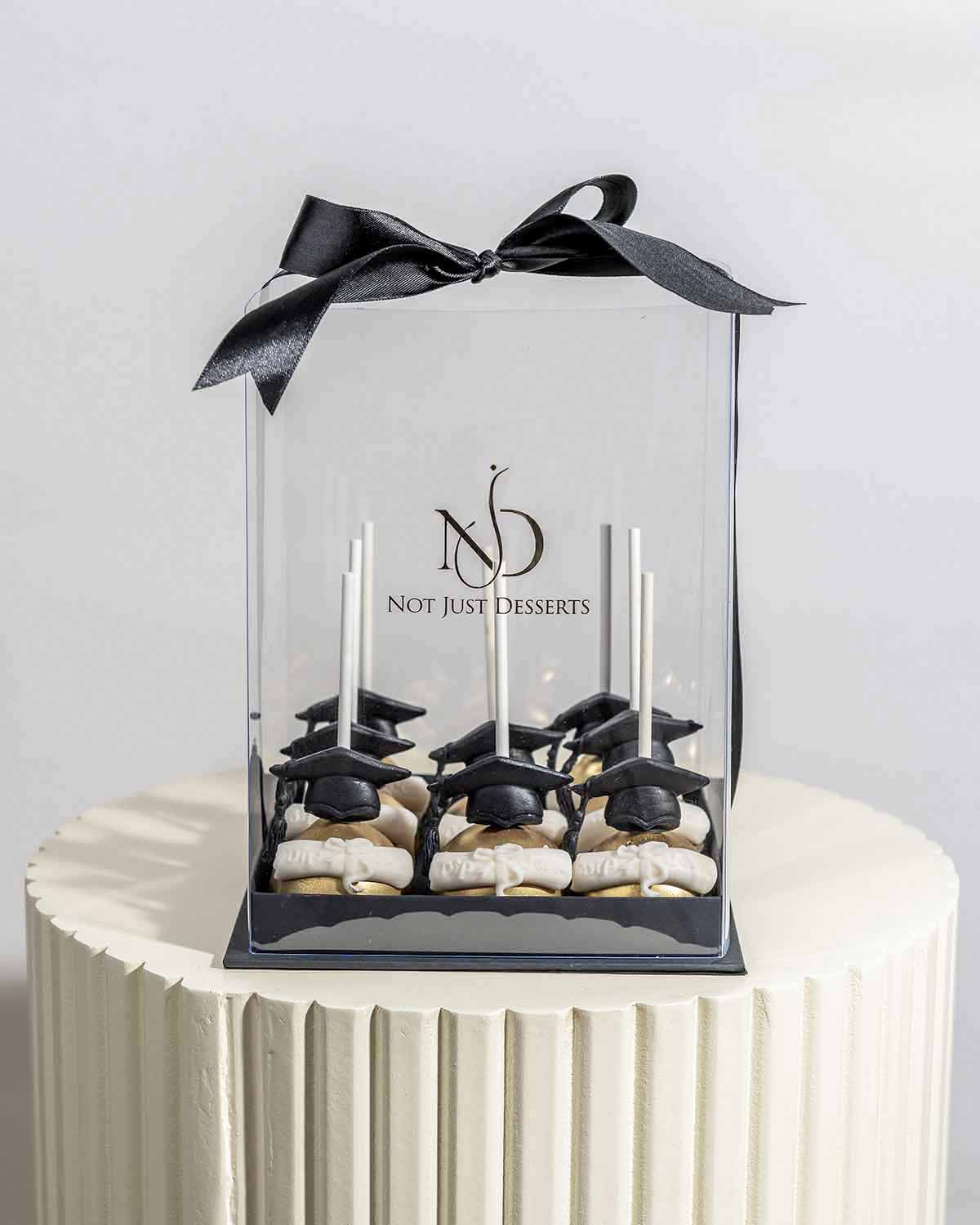 Graduation theme Chocolate Cake pops by NJDChocolate & ConfectioneryYour Gift Contains:• 9 x Graduation theme cake pops• Flavors available: Chocolate/Vanilla/Red Velvet• Chocolate Weight: 670g• Box Size: 16x16x20cmHandling and Storage • Keep away from dir