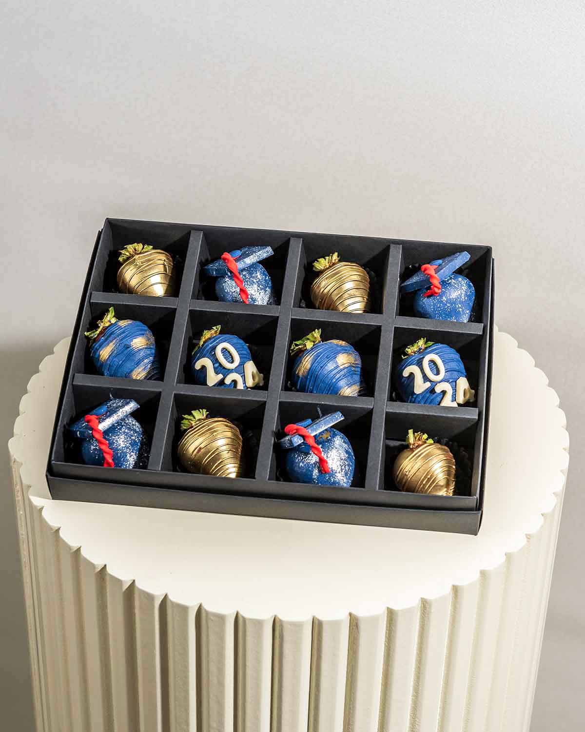 Graduation theme Strawberries by NJDChocolate & ConfectioneryYour Gift Contains:• 12 x Chocolate covered strawberries in Graduation theme• Customizable text • Box Size:24x18x4cmHandling and Storage • Keep away from direct heat and sunlight• Best stored be