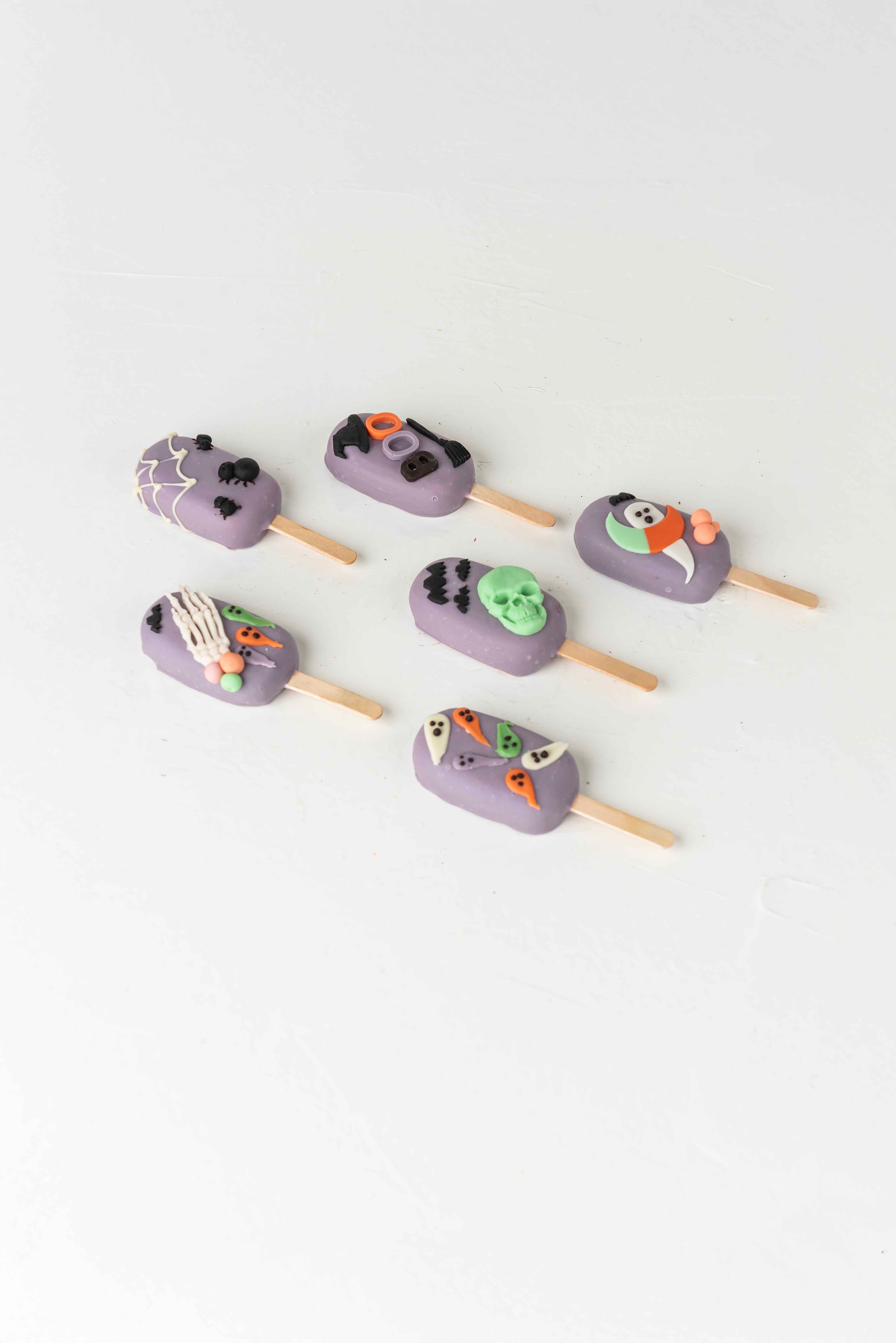 Purple Spooky CakesiclesChocolate & ConfectioneryYour Gift Contains:• 6 Halloween theme Cakesicles• Flavor: Chocolate/Vanilla/Red Velvet• Box Size: 35×14.5x4cmHandling and Storage • Keep away from direct heat and sunlight• Best stored between 12-18 °C• No
