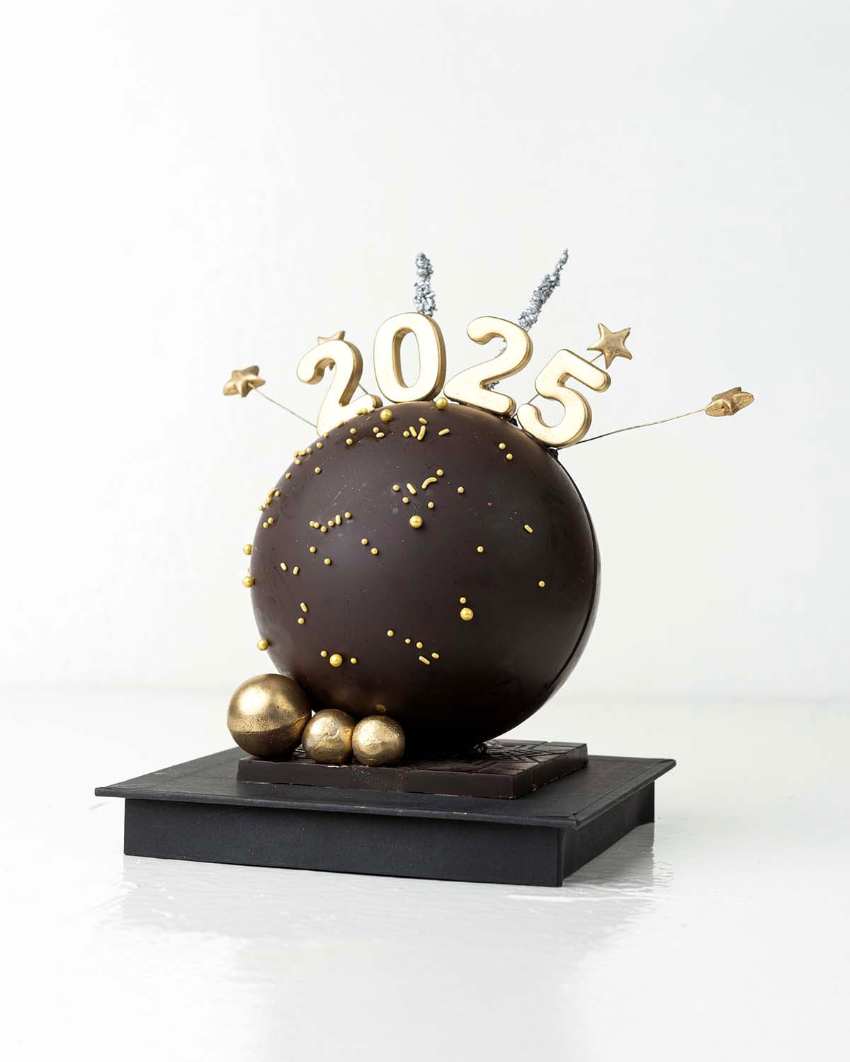 2025 Smash BallChocolate & ConfectioneryYour Gift Contains:• 2025 Theme Dark Chocolate Smash Ball• 11 x Milk Chocolate Assorted Truffles• Flavors: Pistachio, Hazelnut, Speculoos, Peanut Butter and Roche • Chocolate size: 12x12x18cm• 1x Hammer• Chocolate W