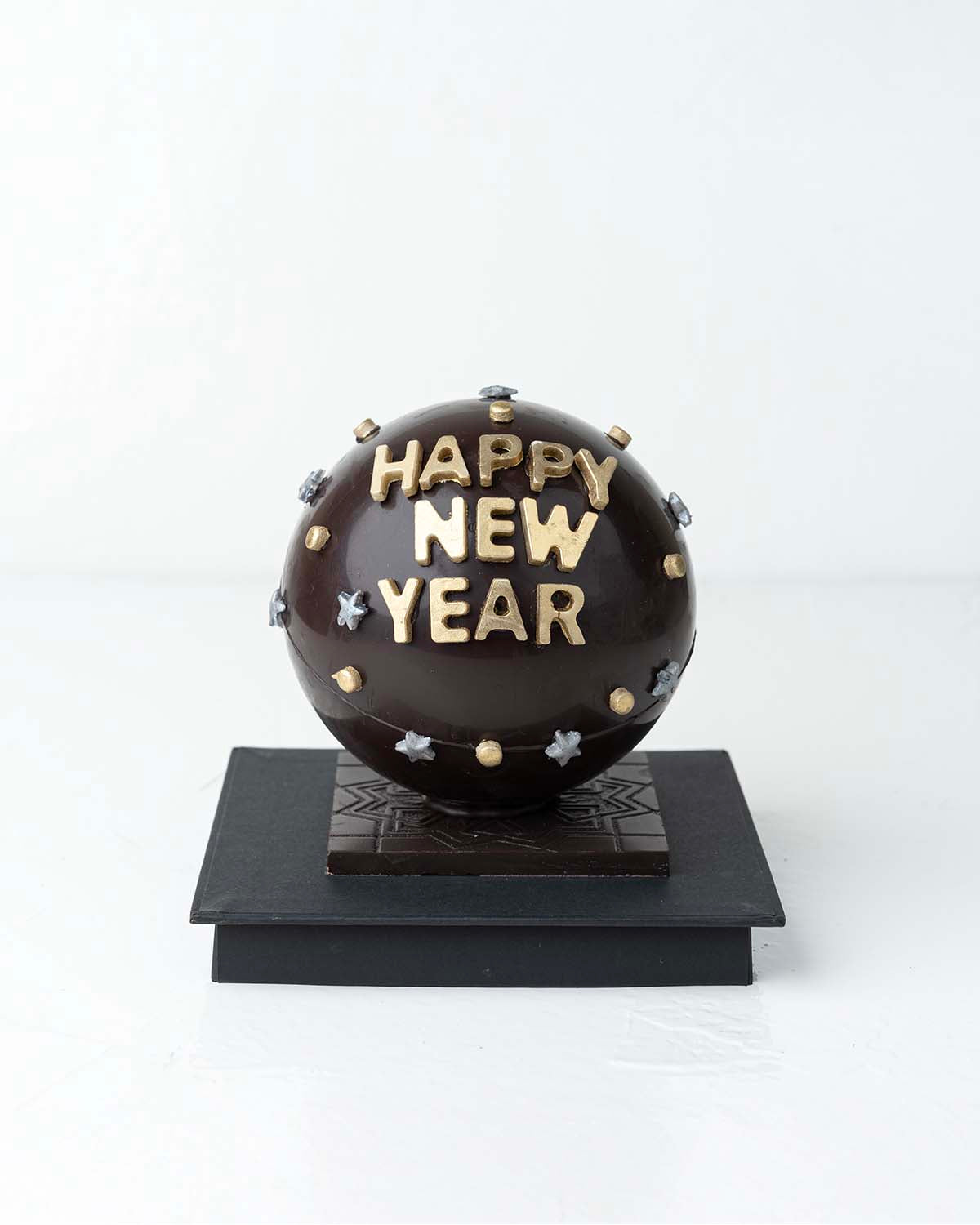 Happy New Year Smash BallChocolate & ConfectioneryYour Gift Contains:• 500grams Dark Chocolate Smash Ball• 11 x Milk Chocolate Assorted Truffles• Flavors: Pistachio, Hazelnut, Speculoos, Peanut Butter and Roche • Chocolate size: 12x12x18cm• 1x Hammer• Box