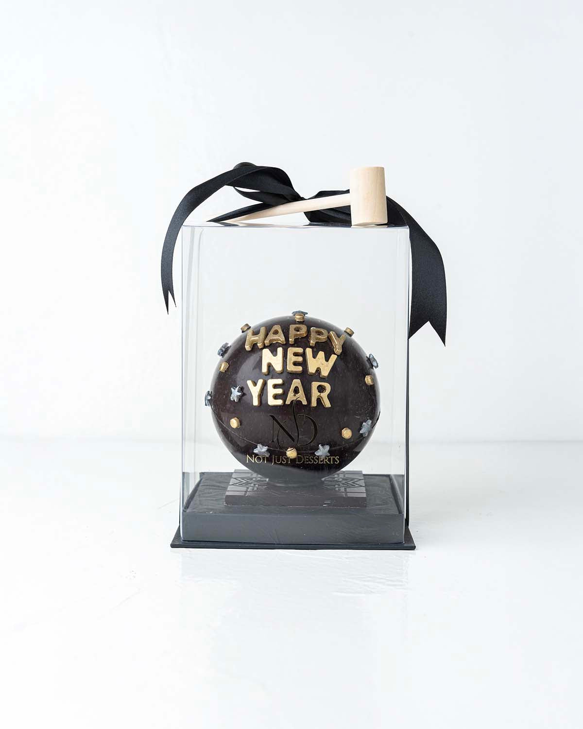Happy New Year Smash BallChocolate & ConfectioneryYour Gift Contains:• 500grams Dark Chocolate Smash Ball• 11 x Milk Chocolate Assorted Truffles• Flavors: Pistachio, Hazelnut, Speculoos, Peanut Butter and Roche • Chocolate size: 12x12x18cm• 1x Hammer• Box