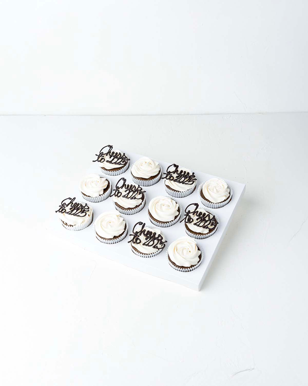 Cheers to 2025 CupcakesChocolate & ConfectioneryYour Gift Contains:• 12 Cheers to 2025 Theme cupcakes• Flavor: Chocolate/Vanilla/Red Velvet• Box Size: 34 x26x14cmHandling and Storage• Keep away from direct heat and sunlight• Best stored between 12-18 °C•