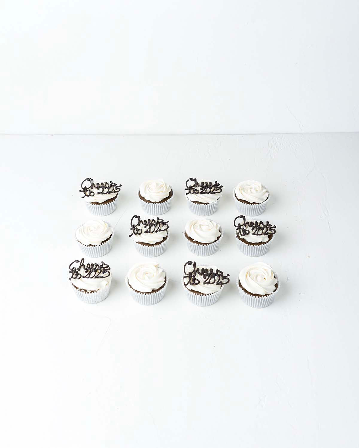 Cheers to 2025 CupcakesChocolate & ConfectioneryYour Gift Contains:• 12 Cheers to 2025 Theme cupcakes• Flavor: Chocolate/Vanilla/Red Velvet• Box Size: 34 x26x14cmHandling and Storage• Keep away from direct heat and sunlight• Best stored between 12-18 °C•