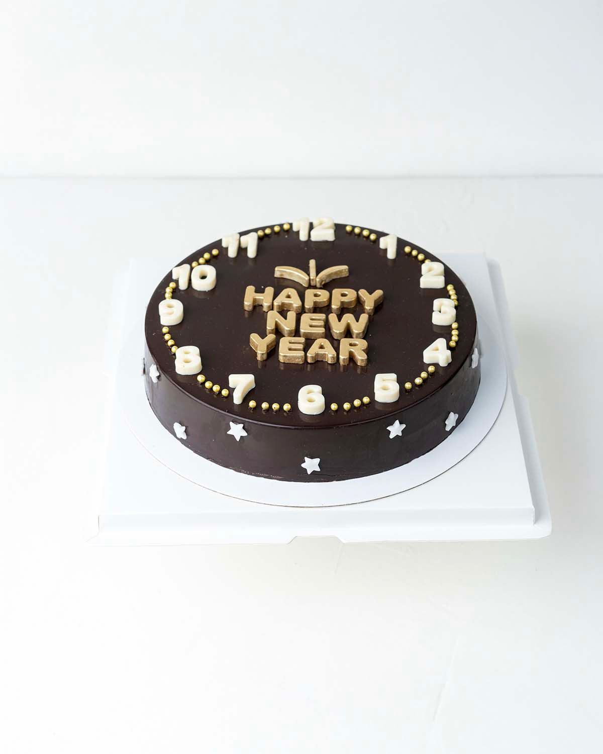 Happy New Year Cake with ChocolateChocolate & ConfectioneryYour Gift Contains:• 600grams Happy New Year Dark • 10 assorted Dark Chocolate Truffles• Flavors: Pistachio, Hazelnut, Speculoos, Peanut Butter and Roche • Chocolate size: 21x21x4cm• 1x Hammer• Bo