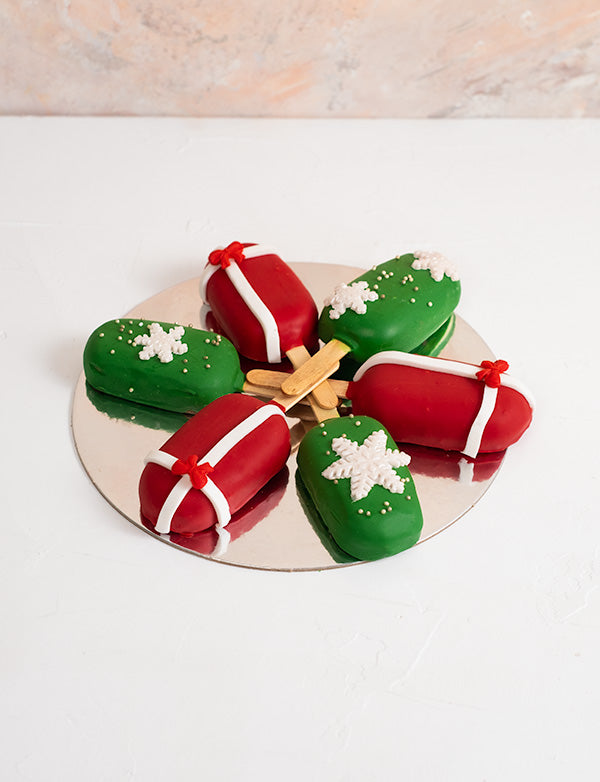 Christmas CakesiclesChocolate & ConfectioneryYour Gift Contains: • 6 pieces Christmas theme Red Velvet and Chocolate flavor cakesicles • Box Size: 18x18x23.5cm Handling and Storage • Keep away from direct heat and sunlight • Best stored between 12-18 °C •