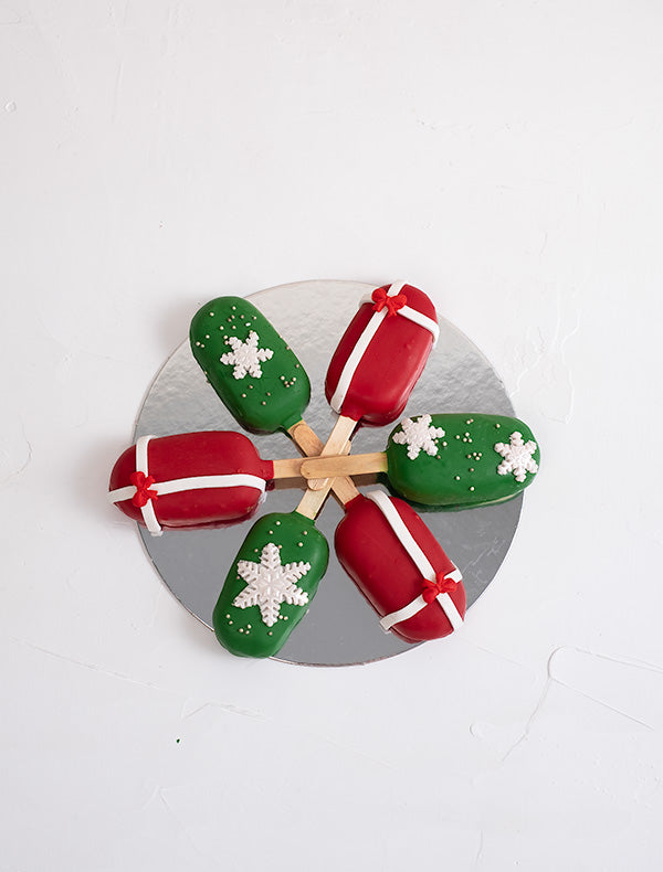 Christmas CakesiclesChocolate & ConfectioneryYour Gift Contains: • 6 pieces Christmas theme Red Velvet and Chocolate flavor cakesicles • Box Size: 18x18x23.5cm Handling and Storage • Keep away from direct heat and sunlight • Best stored between 12-18 °C •