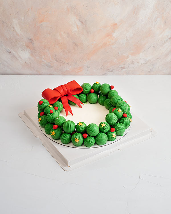 Truffles and Cake pops WreathChocolate & ConfectioneryYour Gift Contains: • Wreath made with 58 Cake pops and Assorted Truffles • Truffles flavors: Pistachio, Hazelnut, Peanut Butter, Sepculoos, Roche, Kinder and Rice Krispies • Cake pop Flavors: Red Velv