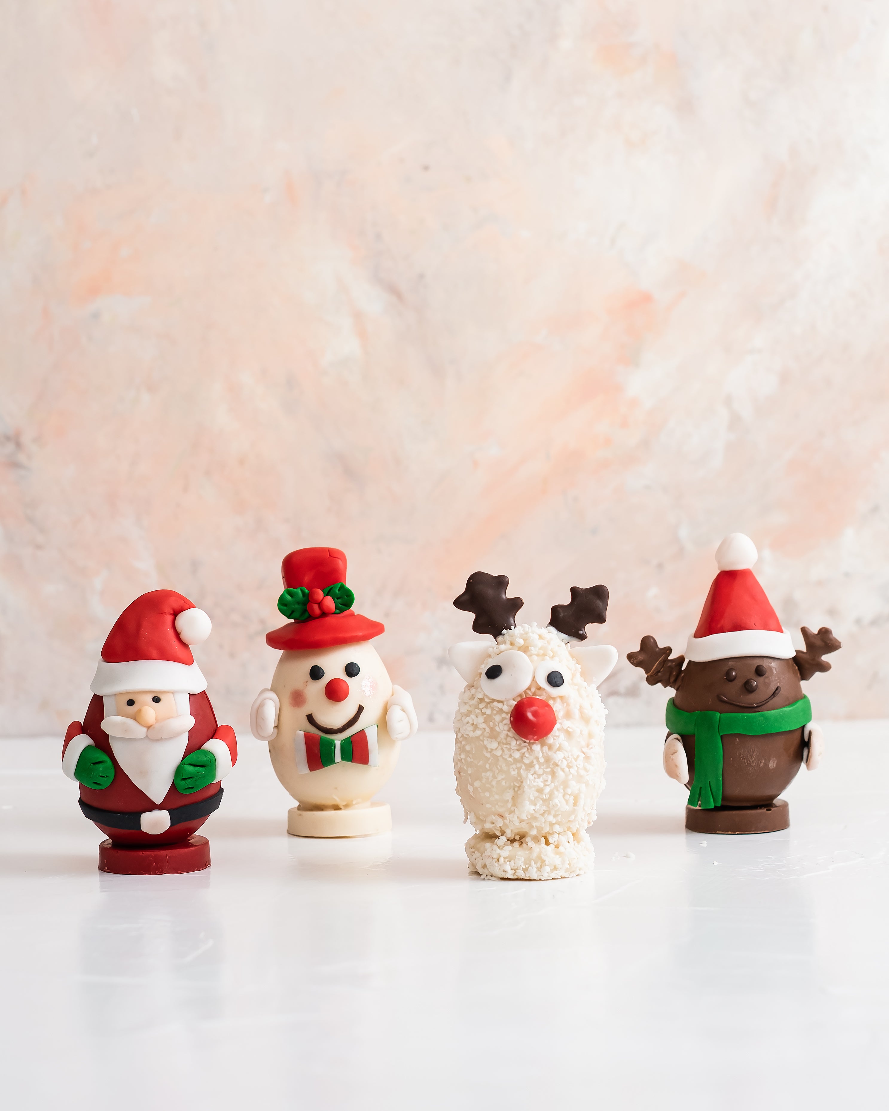 Edible Christmas Characters by NJDChocolate & ConfectioneryYour Gift Contains: • Christmas characters made with assorted Milk and White chocolate • 4 pieces - 125 grams each • Flavor: Hazelnut, Peanut Butter, Roche and Kinder • Weight of Chocolate: 500gra