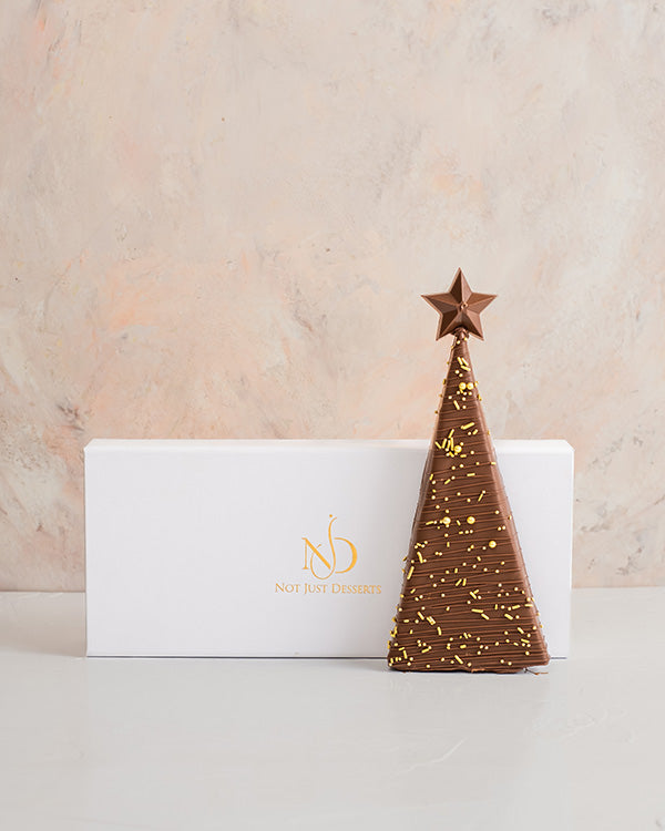 Mini Christmas treeChocolate & ConfectioneryYour Gift Contains: • Triangle shaped chocolate bar with multiple layer filling • Flavor: Pistachio, Roasted Nuts and Biscoff • Weight of Chocolate: 300grams • Box Size: 29x12x4cm Handling and Storage • Keep awa