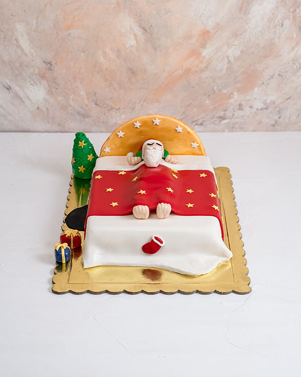Sleeping Santa Cake by NJDChocolate & ConfectioneryYour Gift Contains: • 2kg Vanilla/Chocolate Sponge Cake • Filling: Vanilla cream/Milk Chocolate Ganache Handling and Storage • Keep away from direct heat and sunlight • Best stored between 12-18 °C • Suit
