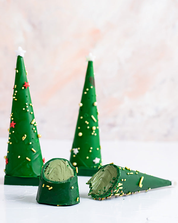 4 Edible Christmas Trees by NJDChocolate & ConfectioneryYour Gift Contains: • 4 mini chocolate cones with rich Pistachio praline fillings and nuts • Weight of Chocolate: 350grams • Box Size: 18x18x14cm Handling and Storage • Keep away from direct heat and