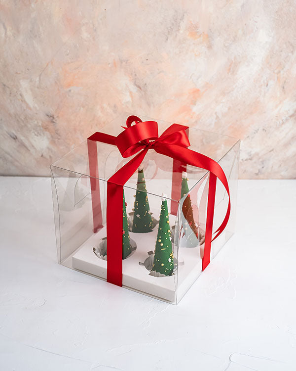 4 Edible Christmas Trees by NJDChocolate & ConfectioneryYour Gift Contains: • 4 mini chocolate cones with rich Pistachio praline fillings and nuts • Weight of Chocolate: 350grams • Box Size: 18x18x14cm Handling and Storage • Keep away from direct heat and