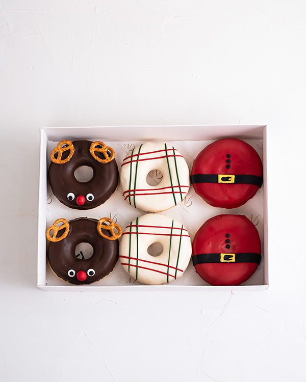 Christmas DonutsChocolate & ConfectioneryYour Gift Contains: • 6 pieces chocolate covered Donuts designed in Christmas theme • Box Size: 24x18x5cm Handling and Storage • Keep away from direct heat and sunlight • Best stored between 12-18 °C • NOT Suitable