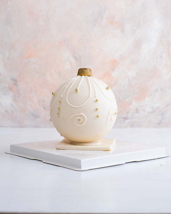 Edible Bauble by NJDChocolate & ConfectioneryYour Gift Contains: • Smash ball with 8 chunky Christmas theme assorted chocolates • Flavors: Pistachio, Sepculoos, Hazelnut, Praline, Peanut Butter • Hammer: 1 • Size of Chocolate: 12x12x14cm • Box Size: 20x20