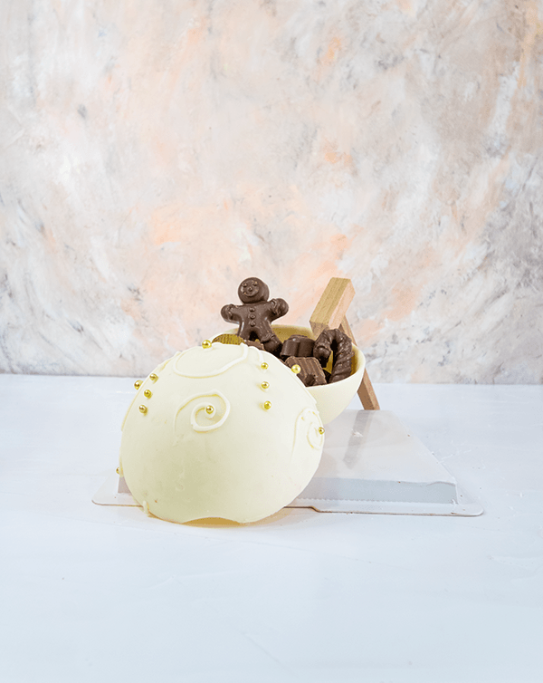 Edible Bauble by NJDChocolate & ConfectioneryYour Gift Contains: • Smash ball with 8 chunky Christmas theme assorted chocolates • Flavors: Pistachio, Sepculoos, Hazelnut, Praline, Peanut Butter • Hammer: 1 • Size of Chocolate: 12x12x14cm • Box Size: 20x20