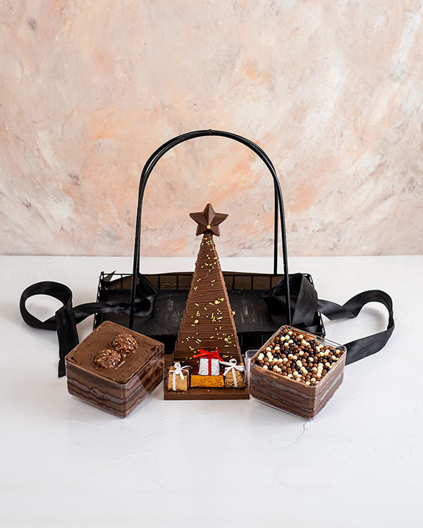Jar Cakes and Chocolate Tree HamperChocolate & ConfectioneryYour Gift Contains: • Christmas tree chocolate bar with Pistachio and Biscoff filling: approx. 400grams • 2 Jar cake in Ferrer and Chocolate Ganache flavors • Weight of Jar cake: 250grams each •