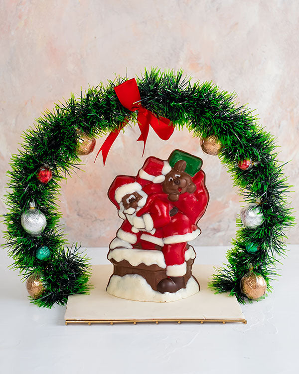 Truffles and 3D Santa by NJDChocolate & ConfectioneryYour Gift Contains: • 10 assorted Milk chocolate truffles decorates as baubles on the wreath • Flavors: Peanut Butter, Hazelnut, Pistachio Praline and Roche • Edible Santa - 500grams approx. • Tray Size