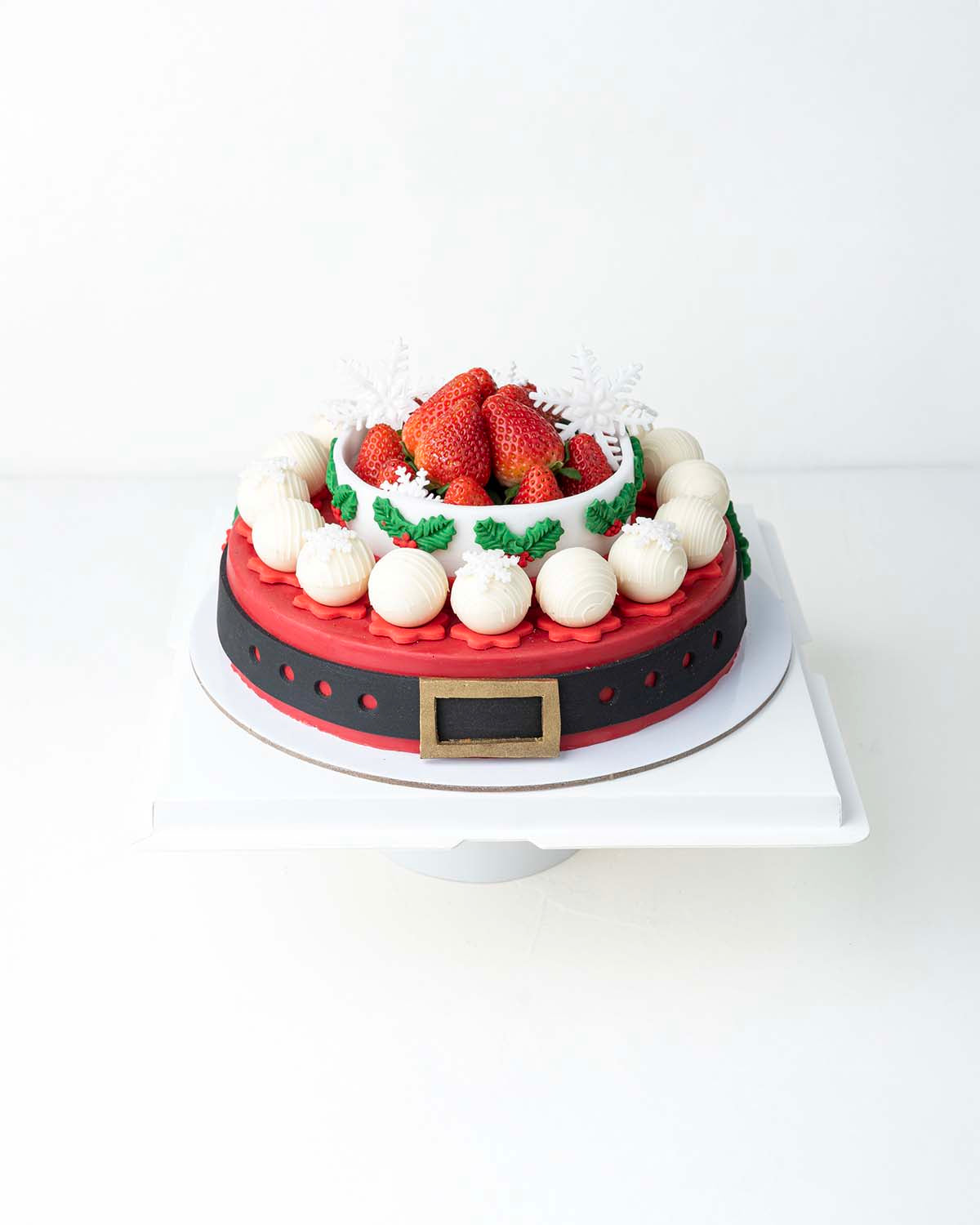 Holiday Season Cake with Fresh StrawberriesChocolate & ConfectioneryYour Gift Contains:• 1300grams Mr. Claus belt cake• 14 Fresh Strawberries • 10 assorted White Chocolate Truffles• Flavors: Pistachio, Hazelnut, Speculoos, Peanut Butter and Roche• Wooden