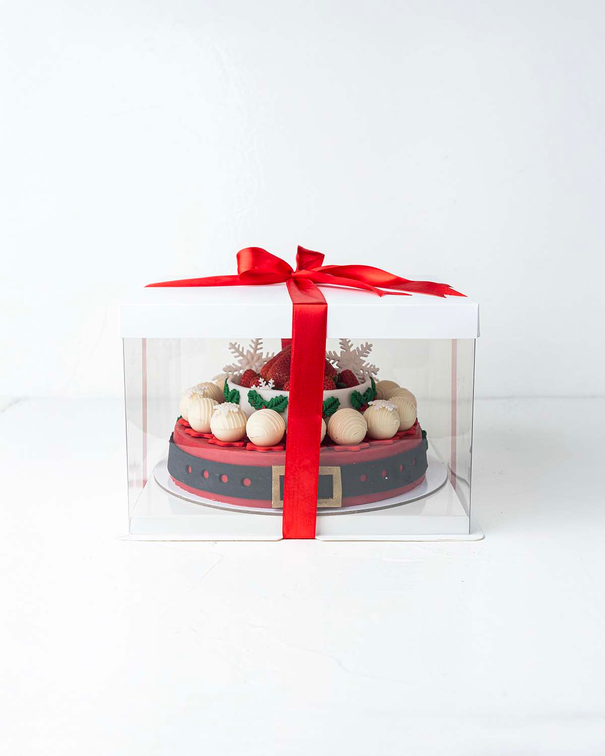 Holiday Season Cake with Fresh StrawberriesChocolate & ConfectioneryYour Gift Contains:• 1300grams Mr. Claus belt cake• 14 Fresh Strawberries • 10 assorted White Chocolate Truffles• Flavors: Pistachio, Hazelnut, Speculoos, Peanut Butter and Roche• Wooden